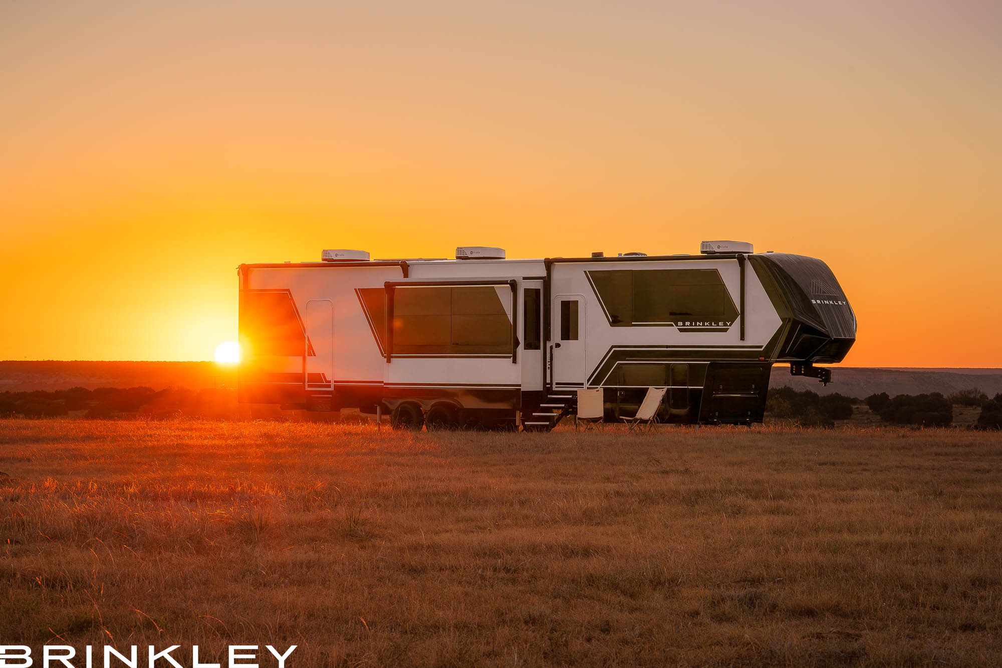Brinkley Model G Luxury Fifth Wheel Toy Hauler in Premium Exterior RVing at Sunset or Sunrise in Texas Doves Rest Resort and Cabins