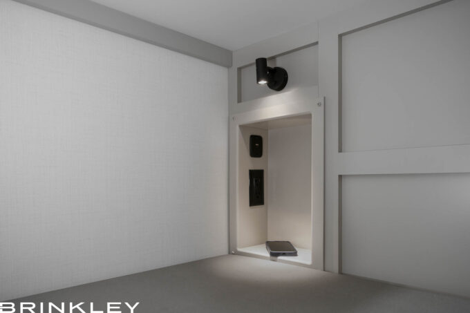 Close-up of the lower bunk storage cubby in a Brinkley Model Z 2810 Fifth Wheel, featuring built-in power outlets, USB charging ports, and white shelving for device storage.