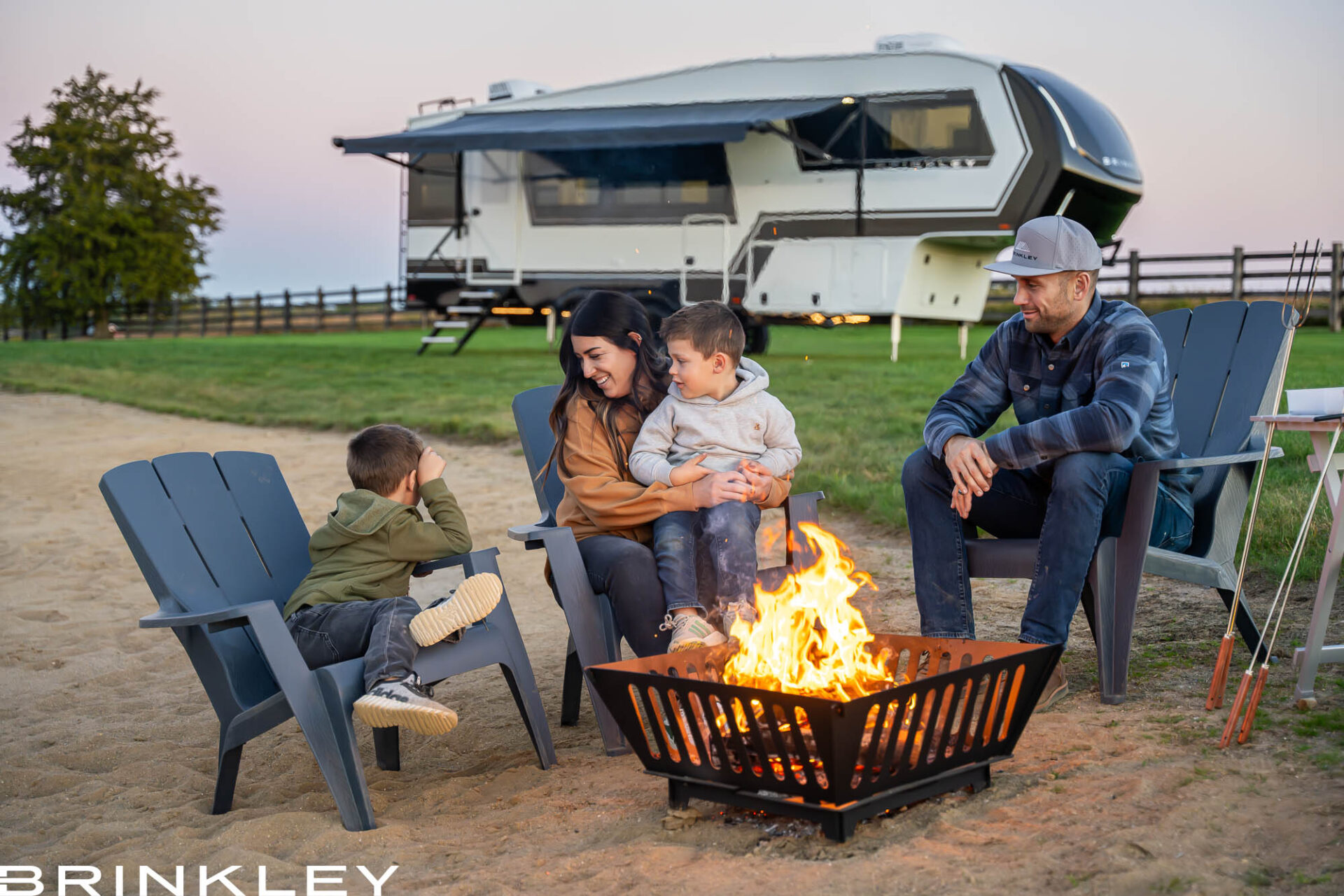 Luxury Fifth Wheel RV RVing with a family around a campfire on a beach. Camping on a warm summer night.